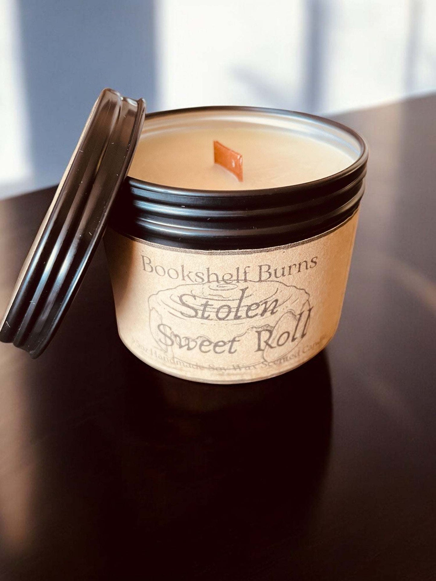 Hand poured scented candle in a stylish tin, inspired by classic stories, perfect for book lovers.