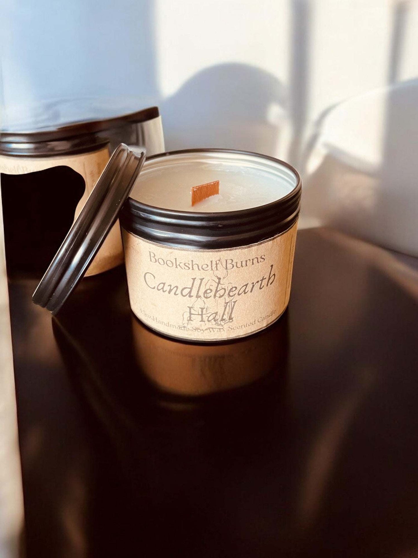 Hand-poured scented candle in a decorative tin, inspired by beloved books, perfect for creating a cozy atmosphere.