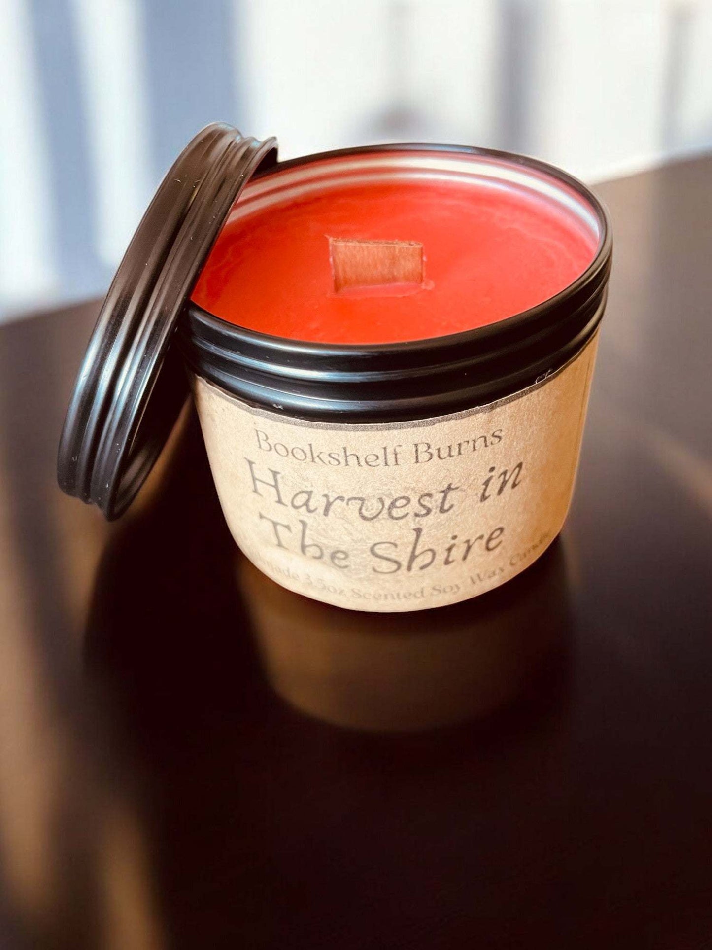 Hand-poured scented candle in tin, inspired by classic stories, eco-friendly soy wax.