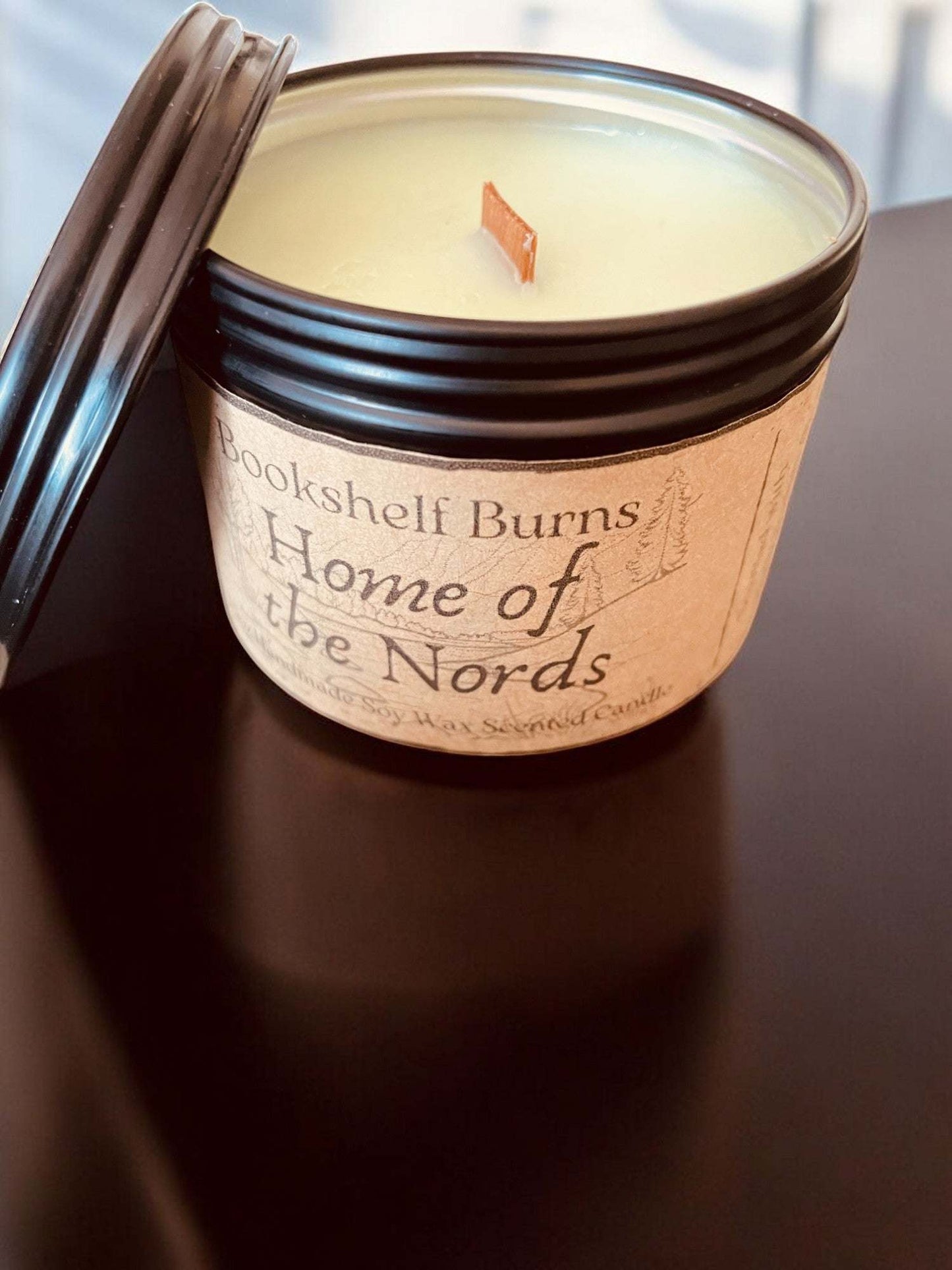 Hand poured scented candle in a decorative tin with a wooden wick.