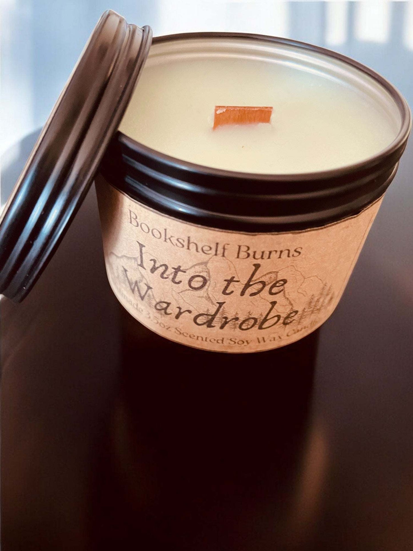 Hand-poured scented soy candle in a decorative tin labeled "Into the Wardrobe."
