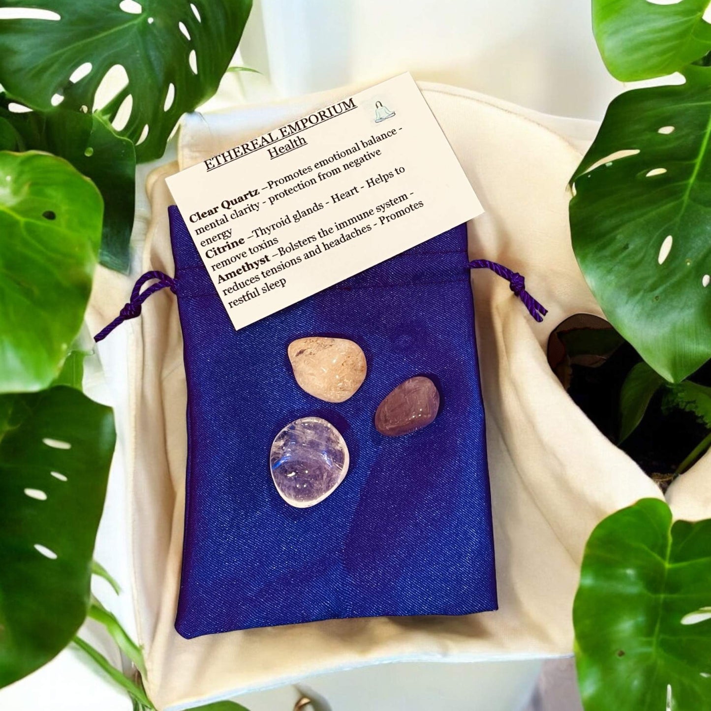 Ethereal Crystal Bags with handpicked crystals and informational card, surrounded by greenery.