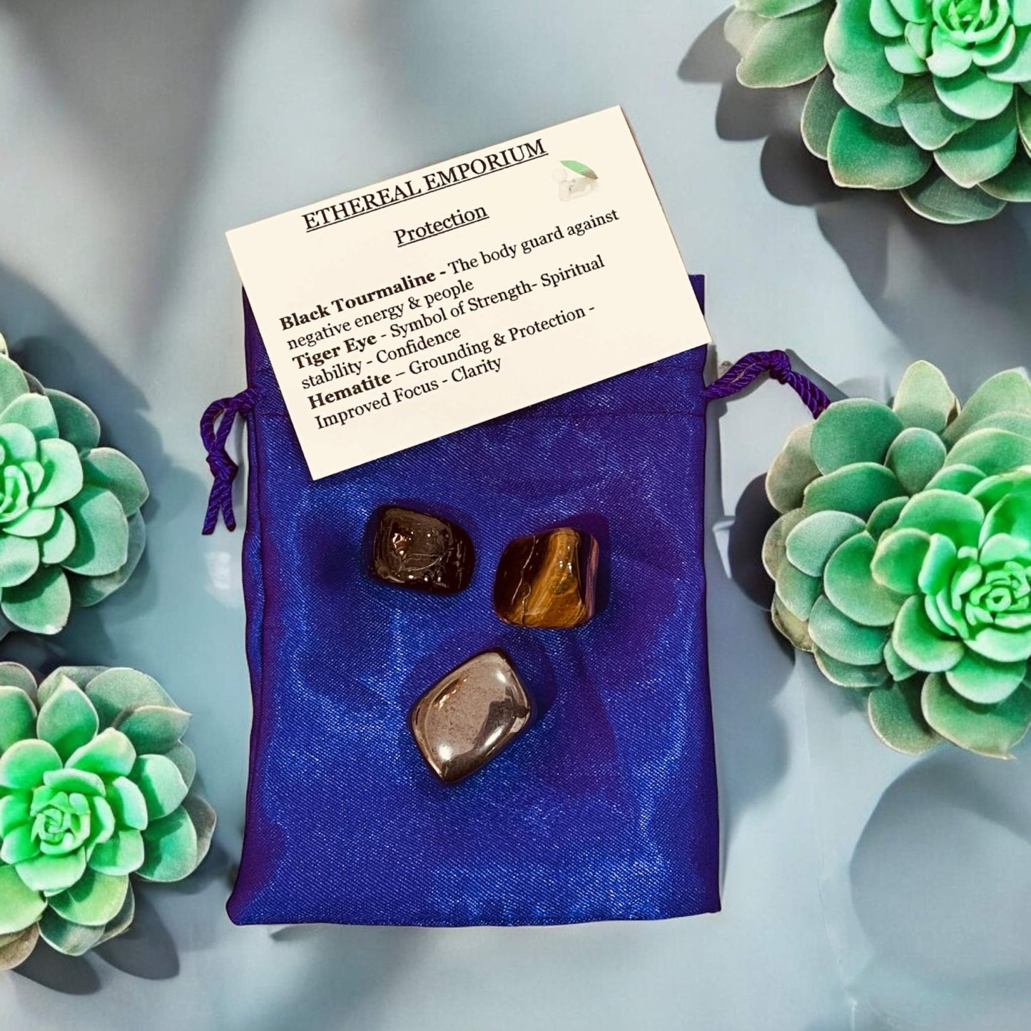 Ethereal Crystal Bags with handpicked crystals and elegant blue pouch displayed among succulents.