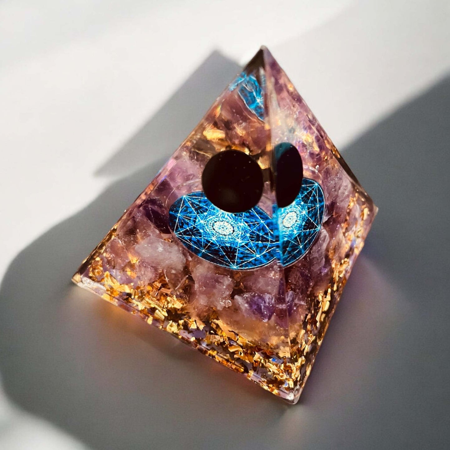 Orgonite pyramid for energy balance and tranquility, aesthetic home decor piece.